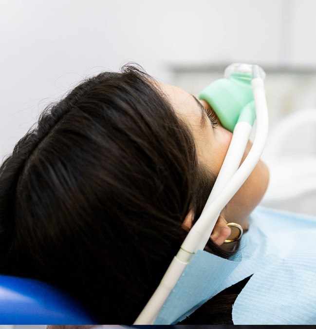 sedated patient sitting in a dental office